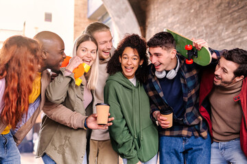 Happy multiracial young friends having fun at city street - Friendship concept.