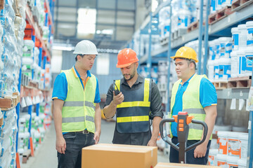 Warehouse workers in helmets checking goods and supplies on shelves with goods background in warehouse worker packing in a large warehouse in a large warehouse. Logistics industry concept..