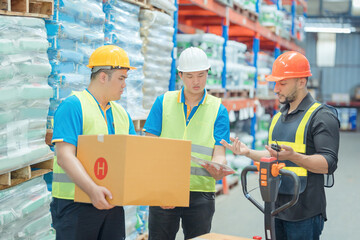 Warehouse workers in helmets checking goods and supplies on shelves with goods background in warehouse worker packing in a large warehouse in a large warehouse. Logistics industry concept..