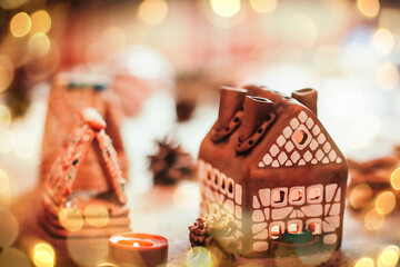 gingerbread house in the background of the Christmas table. beautiful bokeh effect from a garland.