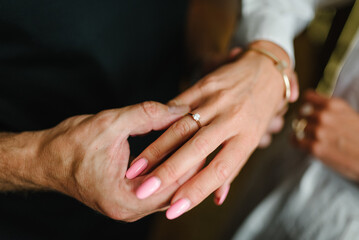 Man holding his girl's hand - Man making a marriage proposal to his girlfriend. Man in love putting an engagement ring on woman finger. Propose. Closeup hands. Offer of hand and heart. Engaged couple.