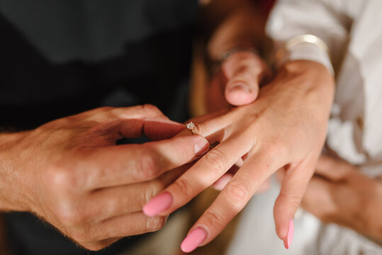 Man in love putting an engagement ring on woman finger. Propose. Closeup hands. Offer of hand and heart. Man holding his girl's hand - Man making a marriage proposal to his girlfriend. Engaged couple.