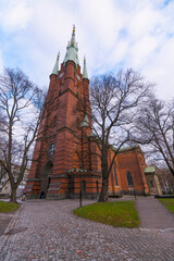 The down town brick church Klara Kyrka a winter day with dark clouds and low sun in Stockholm