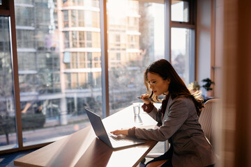 Young Asian businesswoman working on laptop in office.