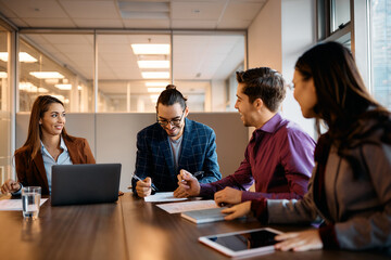Happy Hispanic entrepreneur having business meeting with coworkers in office.