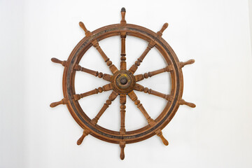 A wooden rudder hangs on a white wall