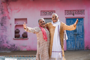 Two old indian villagers giving happy expression out of home. - obrazy, fototapety, plakaty