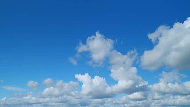 Cloud cumulus and cirrus on different layers clouds nature background. Blue sky with clouds and sun. Nature background of airy cloudscape. Timelapse.