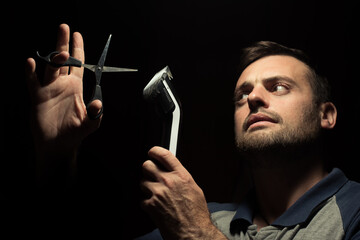 bearded man with scissors on a dark background