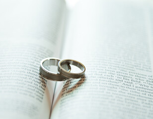 Two wedding rings on a bible page.