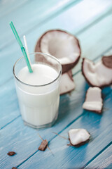 Top view of coconut cocktail in glass with coconut on white wooden table. Selective focus. Tropical