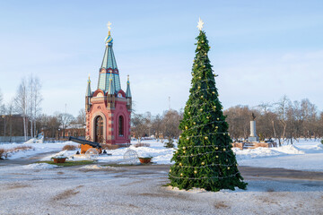 Fototapeta premium New Year tree and chapel of the holy apostles Peter and Paul on a January afternoon. Territory of the Admiralty of Peter the Great. Kronstadt