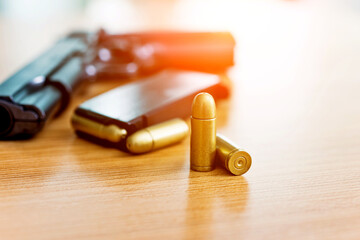 Gun with ammunition on wooden table