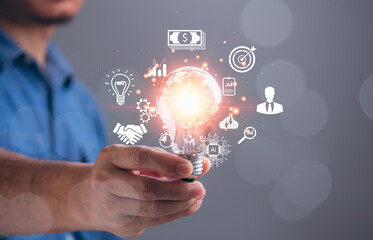 Concept of business strategy, success, 2023 goals, ideas, target, action plan, growth, market, development, investment, innovation technology. Businessman hand holding light bulb sparkling effect
