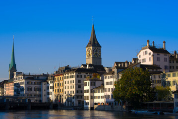 Fototapeta premium Beautiful cityscape of the old town of Zürich with church towers and Limmat River in the foreground on a sunny late summer morning. Photo taken September 22nd, 2022, Zurich, Switzerland.