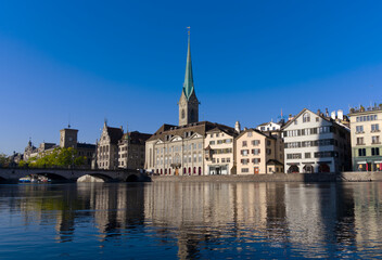Fototapeta na wymiar Beautiful cityscape of the old town of Zürich with Limmat River in the foreground with church Women's Minster on a sunny late summer morning. Photo taken September 22nd, 2022, Zurich, Switzerland.