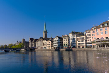 Fototapeta na wymiar Beautiful cityscape of the old town of Zürich with Limmat River in the foreground with church Women's Minster on a sunny late summer morning. Photo taken September 22nd, 2022, Zurich, Switzerland.