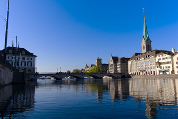 Beautiful cityscape of the old town of Zürich with Limmat River in the foreground with church Women's Minster on a sunny late summer morning. Photo taken September 22nd, 2022, Zurich, Switzerland.