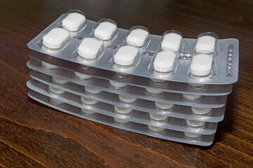 Blisters of tablets on a wooden surface. A medicinal product.