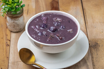 Ginataang Ube bilo bilo is a sweet coconut-based dessert soup with tapioca, chewy rice balls, and a variety of fruits and sweet potato
