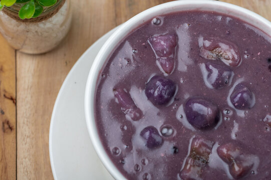 Ginataang Ube bilo bilo is a sweet coconut-based dessert soup with tapioca, chewy rice balls, and a variety of fruits and sweet potato