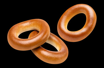 Flying bread rings (bagels, sushki or baranki), isolated on black background