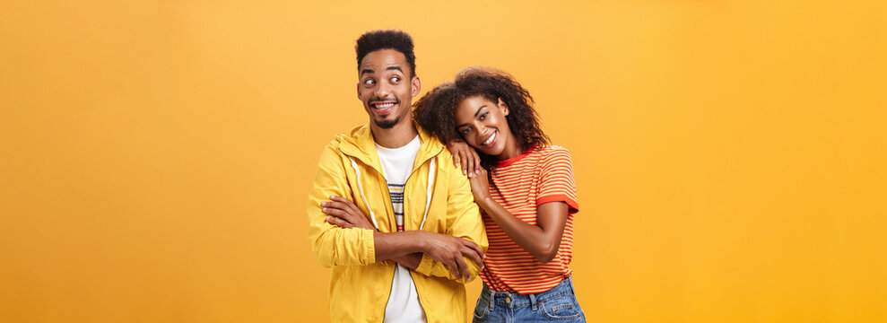 Guy Feeling Happy Girl Lean On His Shoulder Grinning And Chuckling From Happiness Standing Pleased And Joyful Over Orange Background While Woman Hugging Best Friend Upbeat She Can Rely On Him