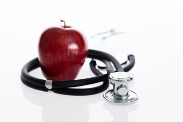 Red apple and stethoscope isolated on white background