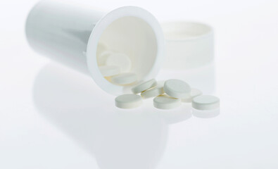 Pills and pill bottle isolated on white background