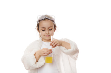 Smart child, lovely little girl, young chemist scientist in lab coat, using laboratory stick, mixing yellow liquid chemical with reagents in a beaker, isolated on white background. Chemistry lesson