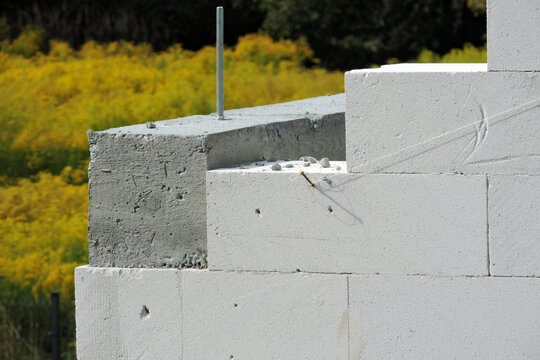 A construction steel pin and a reinforced concrete beam  on the first floor of a house under construction, walls made of autoclaved aerated concrete