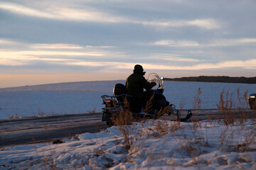 Silhouette of a man in a winter high-speed sleigh in a snowy field.. Winter fun. - 552772432