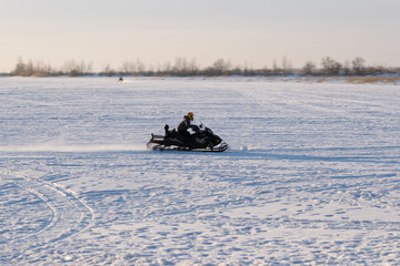 The silhouette of a man on a snow-speed sleigh in a winter field. Winter fun. - 552772465