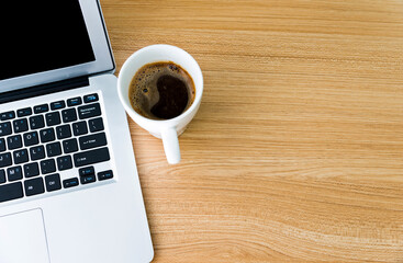 Obraz na płótnie Canvas Desk with laptop and a cup of coffee