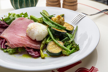 Salad with beef, grilled vegetables and poached egg