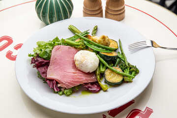 Salad with beef, grilled vegetables and poached egg