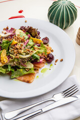 Green salad with salmon, lettuce, cherries, nuts