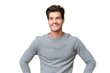 Young handsome caucasian man over isolated background posing with arms at hip and smiling