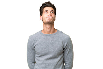 Young handsome caucasian man over isolated background and looking up