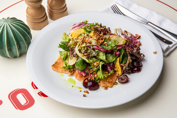 Green salad with salmon, lettuce, cherries, nuts
