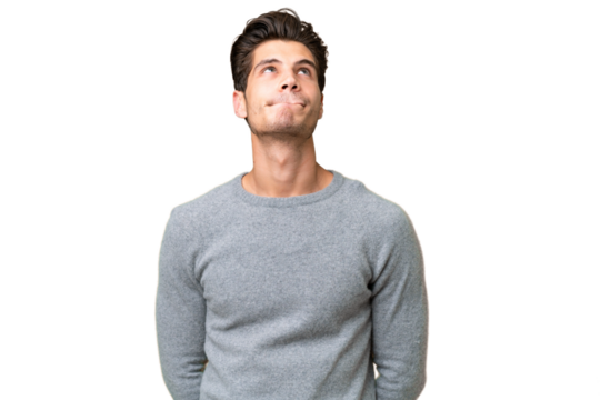 Young handsome caucasian man over isolated background and looking up