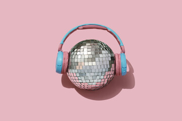 disco ball and headphones on pink backgournd. Concept for party and celebration - obrazy, fototapety, plakaty