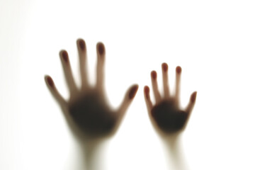 Blurred shadows of hands behind glass, concept of ghosts, zombies, walking corpses
