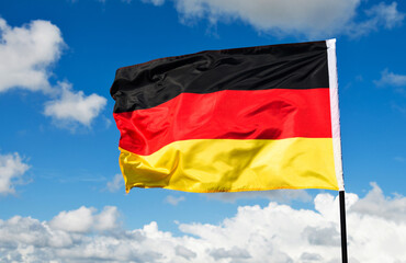 German flag waving against blue sky