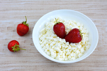 bowl with cottage cheese decorated with strawberry isolated, close-up