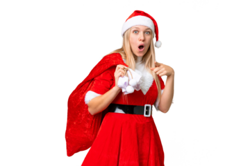 Young blonde woman with christmas hat over isolated chroma key background surprised and pointing front