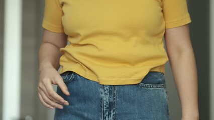 Cropped shot of a women has overweight. she shows excess fat of the waist. she wants lose weight. concept of surgery and subcutaneous fat breakdown.