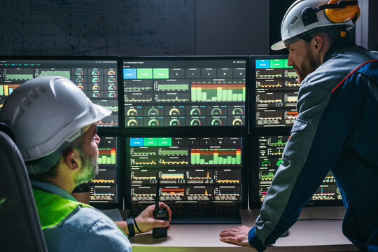 Couple of operators control process on product line uses Industry 4.0 and digital technology on modern factory. Two engineers follow assembly process uses SCADA system which modern technology