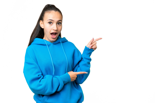 Young Arabian woman over isolated chroma key background surprised and pointing side