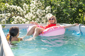 Fun weekend alfresco. Portrait of happy active mother and child in swimsuit in the swimming pool...